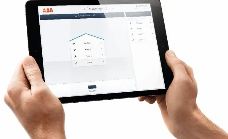 Tablet s aplikací pro plánování podlahy v rukou.