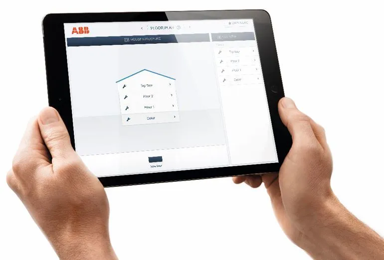 Tablet s aplikací pro plánování podlahy v rukou.