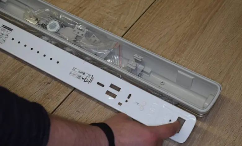Bílá základna pro instalaci LED trubice s viditelnými součástkami.