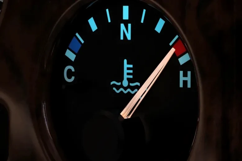 Přehřívání motoru ukazováno na teploměru v autě.