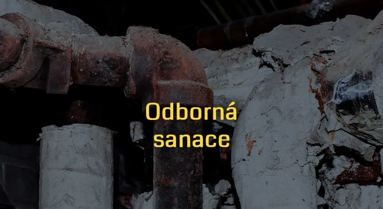 Zrezivělé azbestové trubky v zdi s textem odborná sanace.