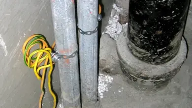 Žlutě-zelené uzemňovací vodiče připojené k kovovým potrubím.