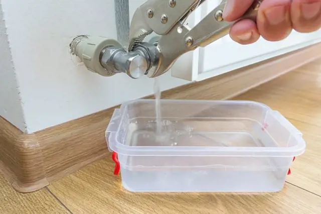 Ručník otáčí ventil pod umyvadlem pro uzavření vody před zimou.