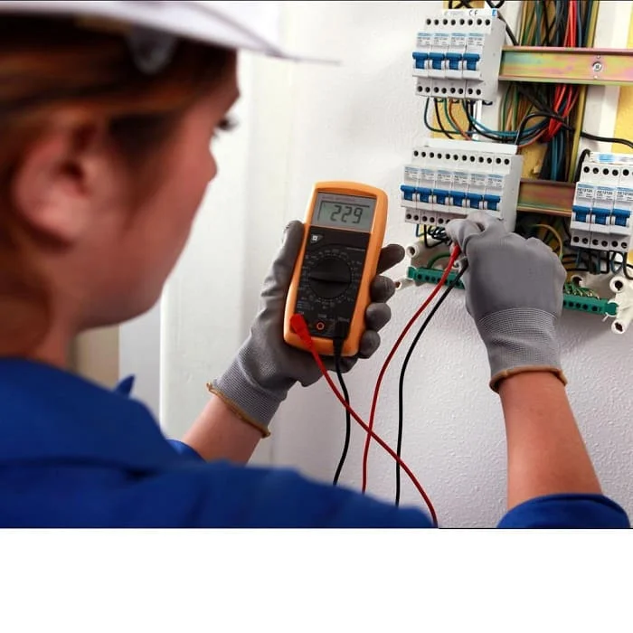 Elektrikář měří napětí v rozvaděči multimetrem při hledání zkratu.