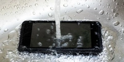 Černý chytrý telefon pod proudem vody s kapkami.