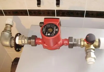 Červené čerpadlo s přípojkami pro instalaci oběhového systému.