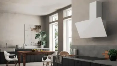 Moderní kuchyň s digestoří nad indukční varnou deskou.