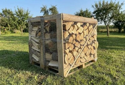 Krabice s dřevo na topení venku v trávníku.