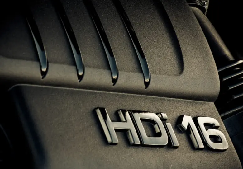 Detailní záběr na logo motoru HDi 16 instalované v automobilovém komponentu.