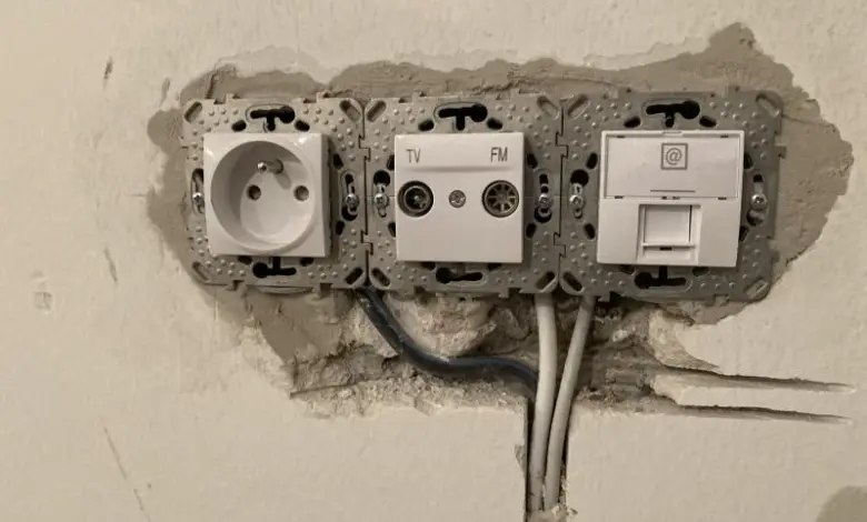 Instalace elektrických zásuvek a konektorů do zdi s viditelným vedením.
