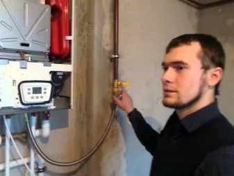 Muž připojuje potrubí k kotli Baxi E35 v interiéru.