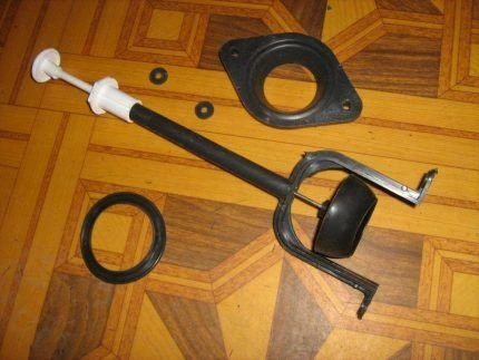 Rozložené součásti ventilu pro plavák v toaletní nádrži.