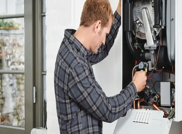 Technik opravuje plynový kotel s viditelnými vnitřními součástkami.
