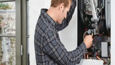 Technik opravuje plynový kotel, který je otevřený.