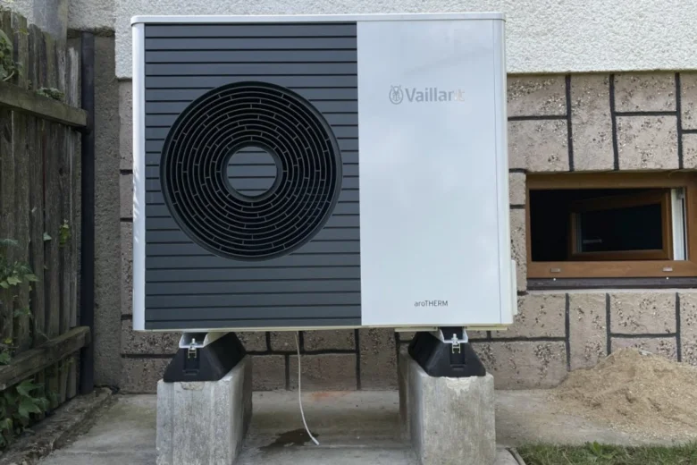 Venkovní jednotka tepelného čerpadla značky Vaillant nainstalovaná na betonových blokách.