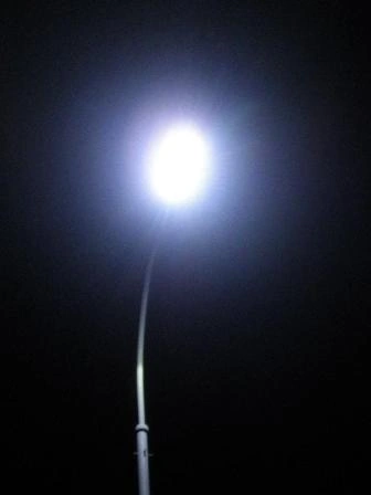 Jasná pouliční lampa na tmavé obloze v noci.