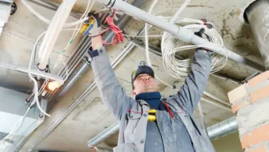 Elektrikář pracuje s kabely v budově ve výstavbě.