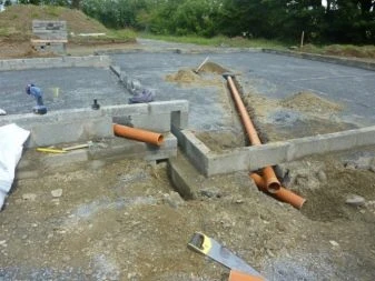 Instalace kanalizačního potrubí na základové ploše s viditelným sklonem.