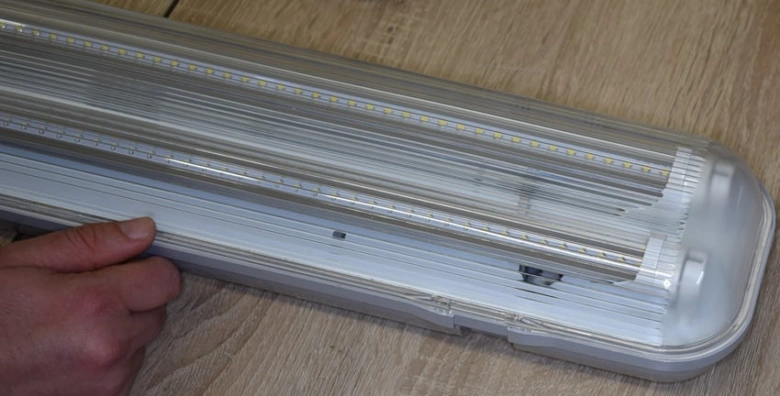 Rozbitá zářivka s viditelnou elektronikou pro návod na opravu.