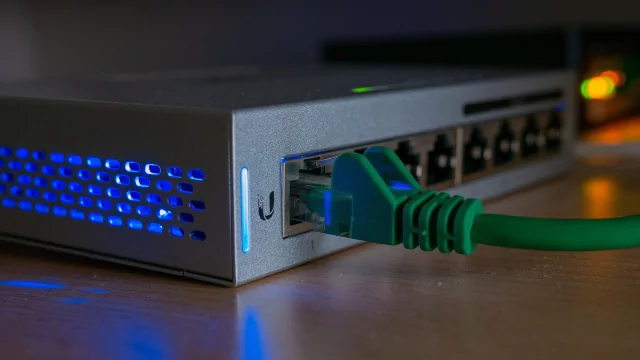 Zelený síťový kabel je připojen k modemu s rozsvícenými světly.