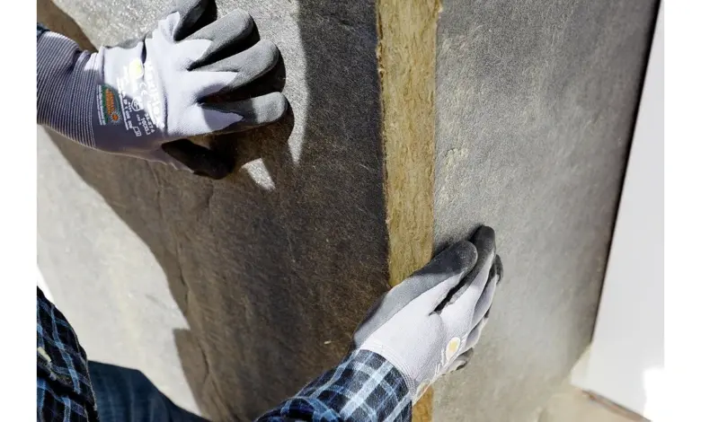 Ruční instalace izolačního materiálu do topného systému.