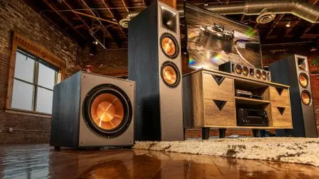 Domácí kino s televizorem, soundbarem a velkým subwooferem v interiéru.