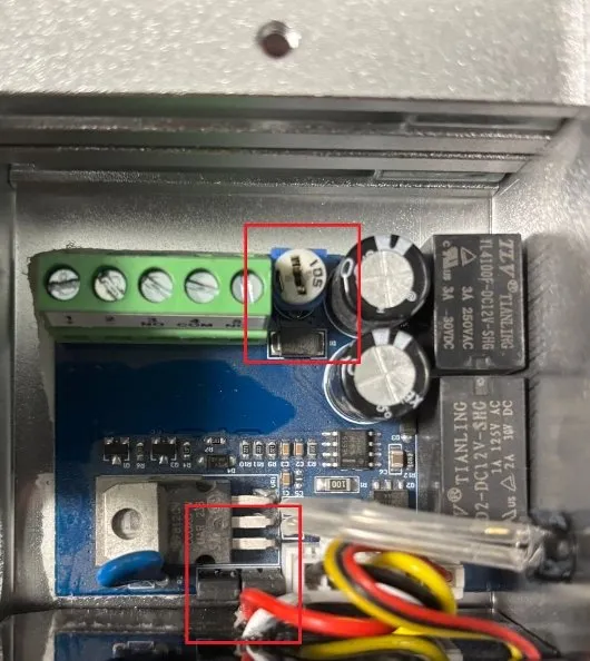 Vnitřní elektronika elektromagnetického zámku s připojenými kabely.