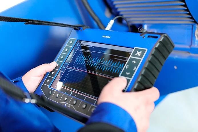 Technik používá přenosný analyzátor pro diagnostiku elektromotoru.