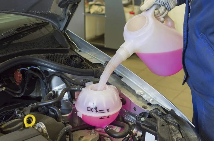 Nalévání nemrznoucí směsi do expanzní nádrži motoru.