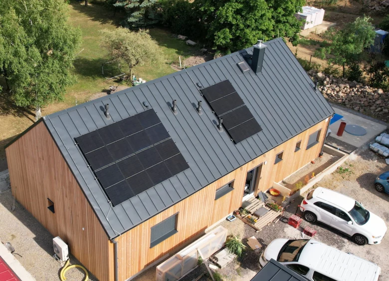 Dům s fotovoltaickými panely na střeji pro domácnost.