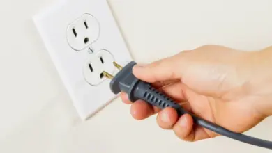 Ruka zapojuje americkou zásuvku do běžné elektrické rozety.