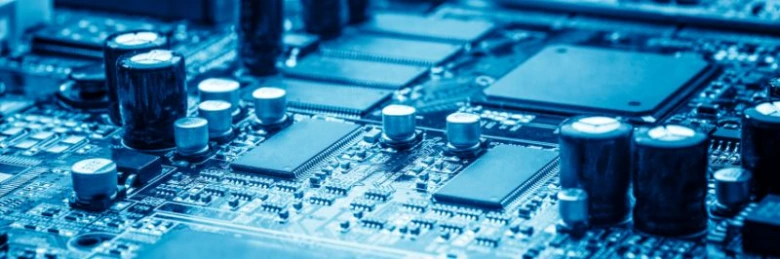 Blízký záběr na elektronickou desku s kondenzátory v modrém osvětlení.