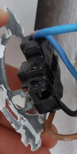 Stará zásuvka bez uzemnění s odhalenými vodiči pro instalaci.