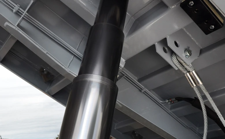 Detailní pohled na hydraulický válec v konstrukci skleníku.