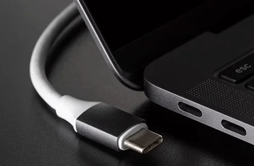 Bílý kabel USB typu C připojený k portu notebooku.
