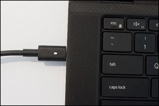 USB-C kabel připojený k notebooku pro nabíjení nebo datový přenos.