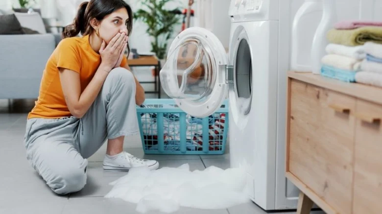 Žena se diví na únik vody z pračky bez funkčního systému Aquastop.