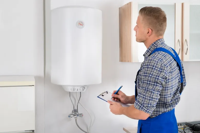 Montér kontroluje elektrický ohřívač vody v domácnosti.