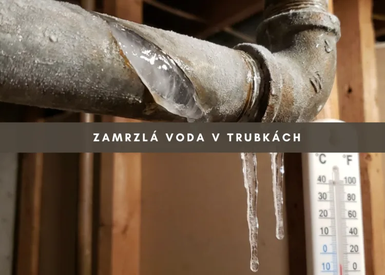 Zamrzlá vodovodní trubka s ledem a kapajícími kapičkami.