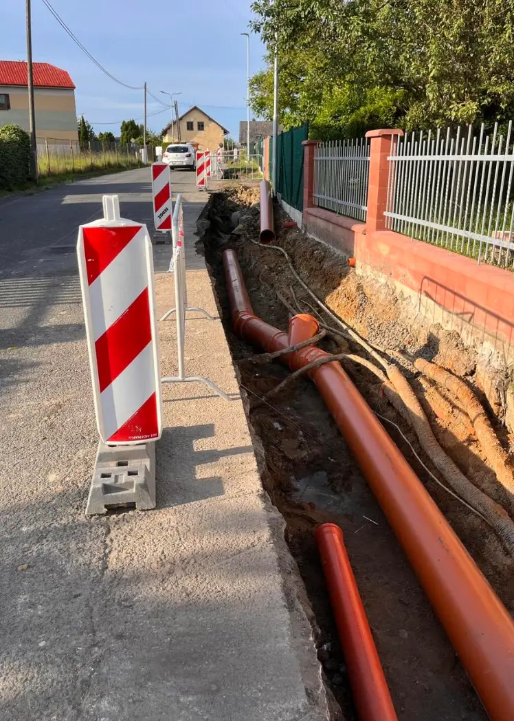 Zasazení kanalizačních trubek v příkopu na ulici
