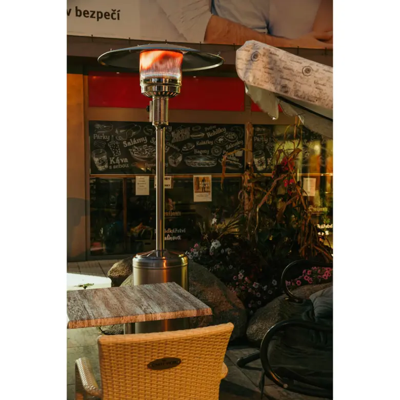 Venkovní plynové topidlo na terase restaurace v noci.