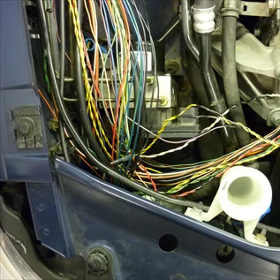 Odkryté automobilové elektrické kabely v interiéru vozu.