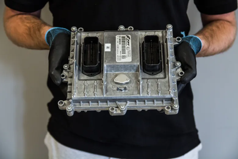 Technik drží řídící jednotku ECU pro diagnostiku poruch.