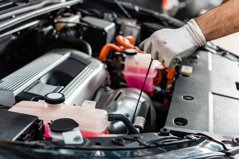 Mechanik kontroluje hladinu oleje v motoru automobilu.