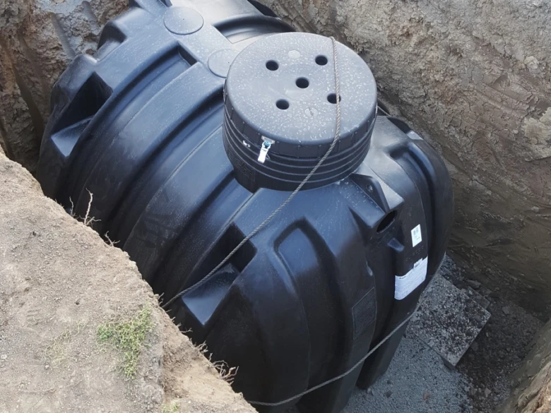 Černá plastová nádrž pro vodu nebo septik při instalaci do jámy.