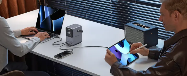 USB hub nabíjí notebook, tablet a telefon na pracovním stole.