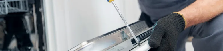 Ruční instalace myčky nádobí pomocí šroubováku.