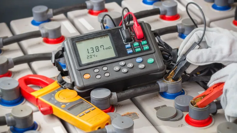 Technik pro měření napětí baterie s digitálním multimetrem.