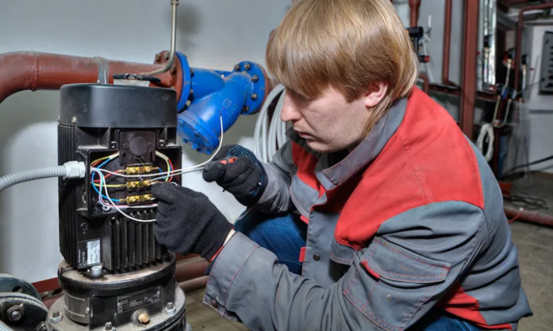 Technik opravuje elektrické spoje uvnitř elektromotoru.
