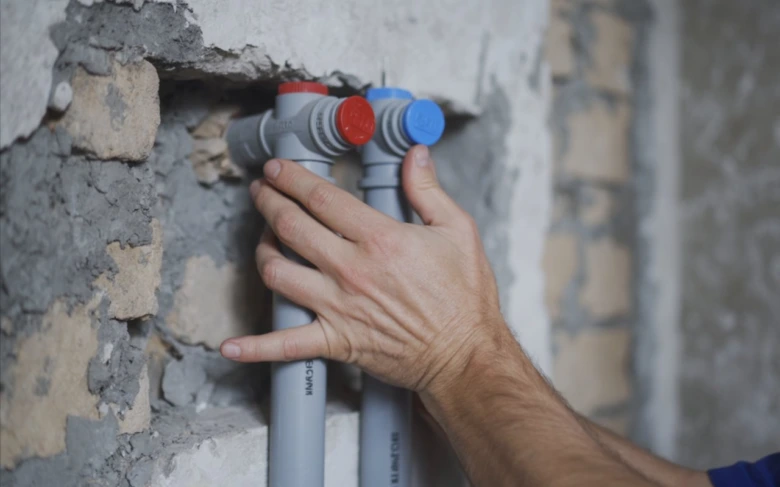 Ruční instalace potrubí pro vytápění v rodinném domě.